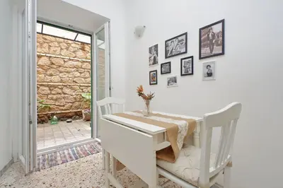 a white dining room with a table and a window at Charming Nest Steps from the Vatican in Rome
