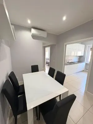 a dining room with a white table and black chairs at Fortis Domus in Rome