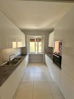 a kitchen with white cabinets and a sink and a window at Fortis Domus in Rome