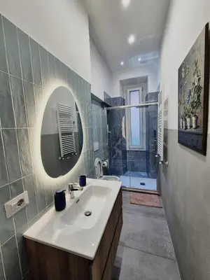 a dining room with a glass table and white chairs at Colosseum Apartment, 3 bedrooms, 3 baths, large living room with a sofa bed, the apartment can accommodate 8 people in Rome