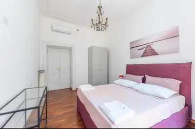 a small bedroom with a bed and a window at Colosseum Apartment, 3 bedrooms, 3 baths, large living room with a sofa bed, the apartment can accommodate 8 people in Rome