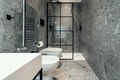 a bathroom with a toilet and a glass shower at The Rubens Spagna in Rome