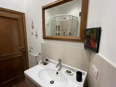 a bathroom with a white sink and a mirror at 7550rome P&J's cozy Trastevere Apartment in Rome