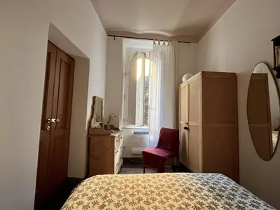 a bedroom with a bed and a window and a chair at 7550rome P&J's cozy Trastevere Apartment in Rome