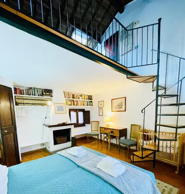 a bedroom with a blue bed and a staircase at Very Special Place in the heart of Rome in Rome