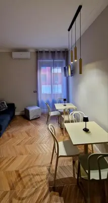 a living room with tables and chairs and a couch at LeChiaviDiCasa - Via Camilla in Rome