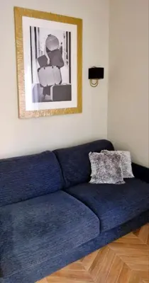 a blue couch in a living room with a picture at LeChiaviDiCasa - Via Camilla in Rome