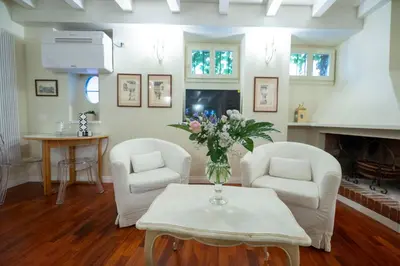 a living room with two chairs and a vase of flowers on a table at Piazza Navona Ivy Retreat- Under the Roman Light in Rome
