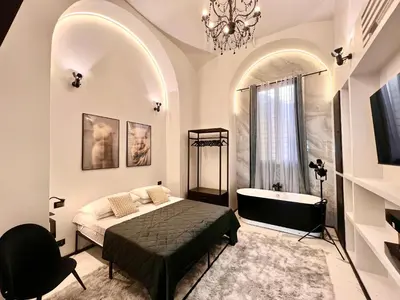 a bedroom with a bed and a tub and a chandelier at Romantic Rome Suite Aureliana in Rome