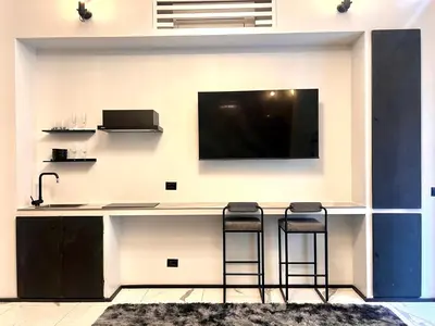 a kitchen with a bar with a tv on a wall at Romantic Rome Suite Aureliana in Rome