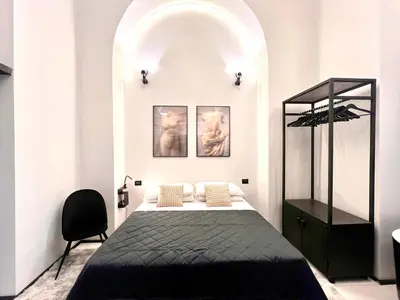 a bedroom with a bed and a chair at Romantic Rome Suite Aureliana in Rome