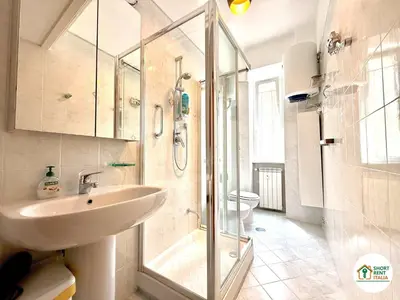 a bathroom with a sink and a glass shower at San Giovanni - Minerva House in Rome