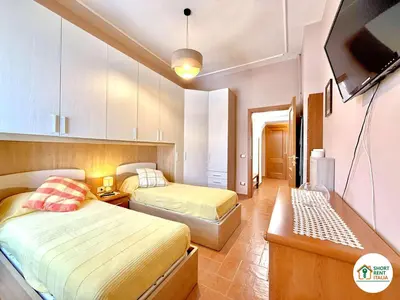 a bedroom with two beds and a television in it at San Giovanni - Minerva House in Rome