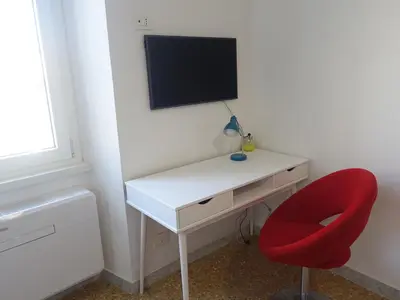 a white desk with a red chair and a television at PiccoloPrincipeAirbnb - Saint Peter area in Rome