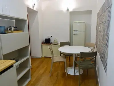 a kitchen with a table and chairs and a refrigerator at PiccoloPrincipeAirbnb - Saint Peter area in Rome