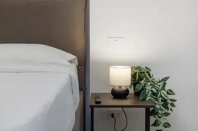 a lamp on a night stand next to a bed at La Dimora di Piazza Mazzini in Rome