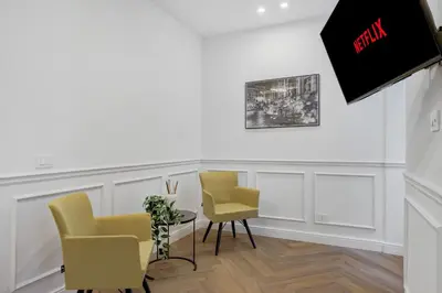 a room with two chairs and a table and a tv at La Dimora Luxury Piazza Mazzini in Rome