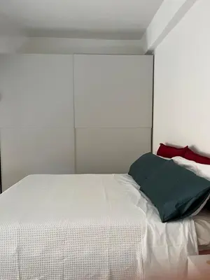 a bedroom with a white bed with a green pillow at Terni 74 V&B Rock House in Rome