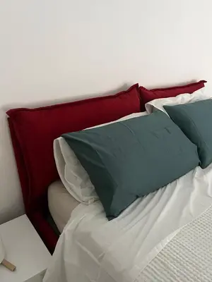 a bed with red and green pillows on it at Terni 74 V&B Rock House in Rome