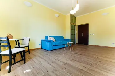 a living room with a blue couch and a table at Volpetti Experience-Suite in Vatican City in Rome