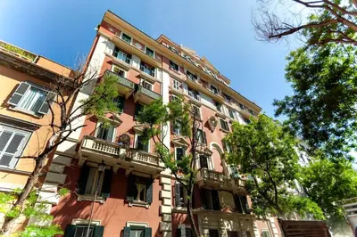 a tall red brick building with a balcony at Volpetti Experience-Suite in Vatican City in Rome