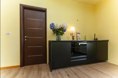 a room with a black door and a vase of flowers at Volpetti Experience-Suite in Vatican City in Rome