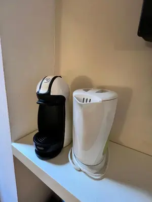 a bathroom with a toilet and a coffee maker on a shelf at San Pietro Charme in Rome