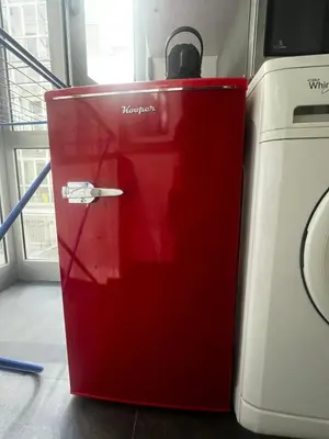 a red refrigerator sitting next to a washing machine at Mina's House in Rome