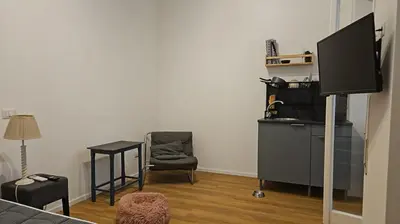 a living room with a tv and a chair at Mina's House in Rome