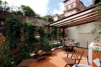 an outdoor patio with chairs and a table and a building at 931 Rome Montefiore apartment in Rome