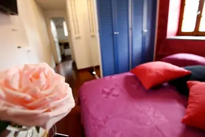 a living room with a pink couch and red pillows at 931 Rome Montefiore apartment in Rome