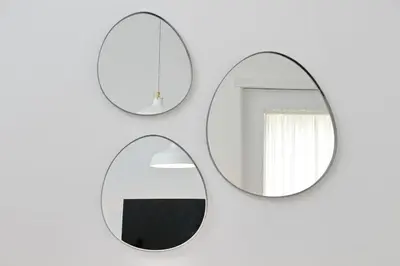 two round mirrors hanging on a white wall at Brand New Modern Apt 2 Stops to Colosseum in Rome