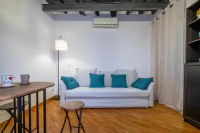 a living room with a white couch with blue pillows at Imperial Forum House in Rome