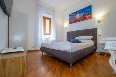 a bedroom with a large bed and a desk at Imperial Forum House in Rome