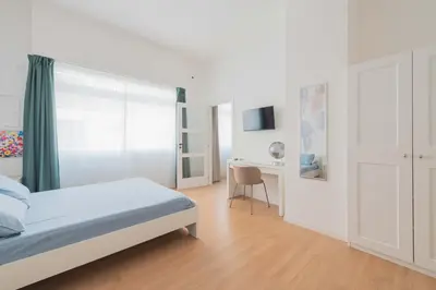 a white bedroom with a bed and a desk at ZanzurMiddleHouse Apartment in Rome