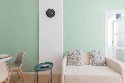 a living room with a couch and a clock on the wall at ZanzurMiddleHouse Apartment in Rome