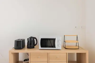 a microwave oven sitting on top of a wooden table at ZanzurMiddleHouse Apartment in Rome