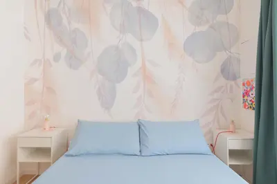 a bedroom with a blue bed with a floral wallpaper at ZanzurMiddleHouse Apartment in Rome