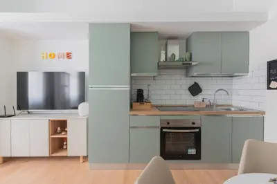 a kitchen with green and white cabinets and a sink at ZanzurMiddleHouse Apartment in Rome