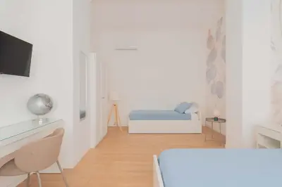 a white room with a bed and a desk at ZanzurMiddleHouse Apartment in Rome
