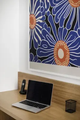 a laptop computer sitting on a wooden desk with a painting at Casina Albani in Rome