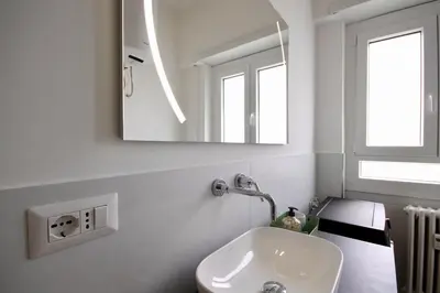 a white bathroom with a sink and a mirror at HC - Charming Apartment in Vigna Clara in Rome
