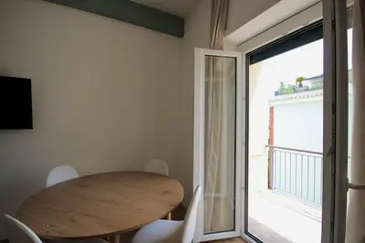 a dining room with a wooden table and a sliding glass door at HC - Charming Apartment in Vigna Clara in Rome