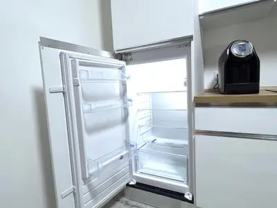 an empty refrigerator with its door open in a kitchen at Casa della Musica - Guesthouse in Rome