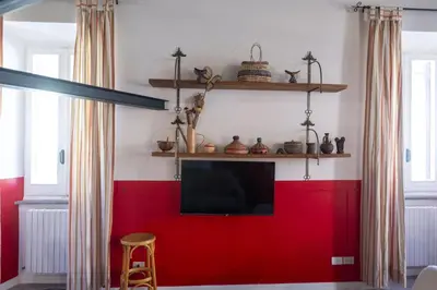 a living room with a red wall and a tv at The Scarlet Loft in Trastevere in Rome