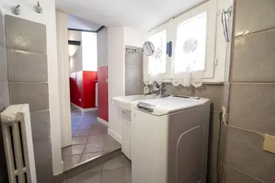 a bathroom with a sink and a washing machine at The Scarlet Loft in Trastevere in Rome