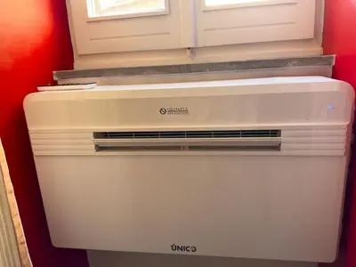 a white refrigerator freezer in a room with a window at The Scarlet Loft in Trastevere in Rome