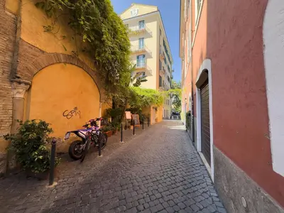 an alley with a motorcycle parked next to a building at The Scarlet Loft in Trastevere in Rome