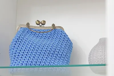 a blue crocheted purse sitting on a glass shelf at Makà, una struttura dal fascino unico in Rome
