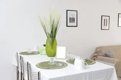 a white table with a green vase on it at Makà, una struttura dal fascino unico in Rome